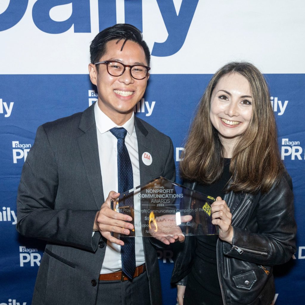 A picture of Nick Gee, Advocacy Manager, and Yamuna Hopwood, Communications Manager, posing with the PR Daily Nonprofit Communications Awards Grand Prize Award.