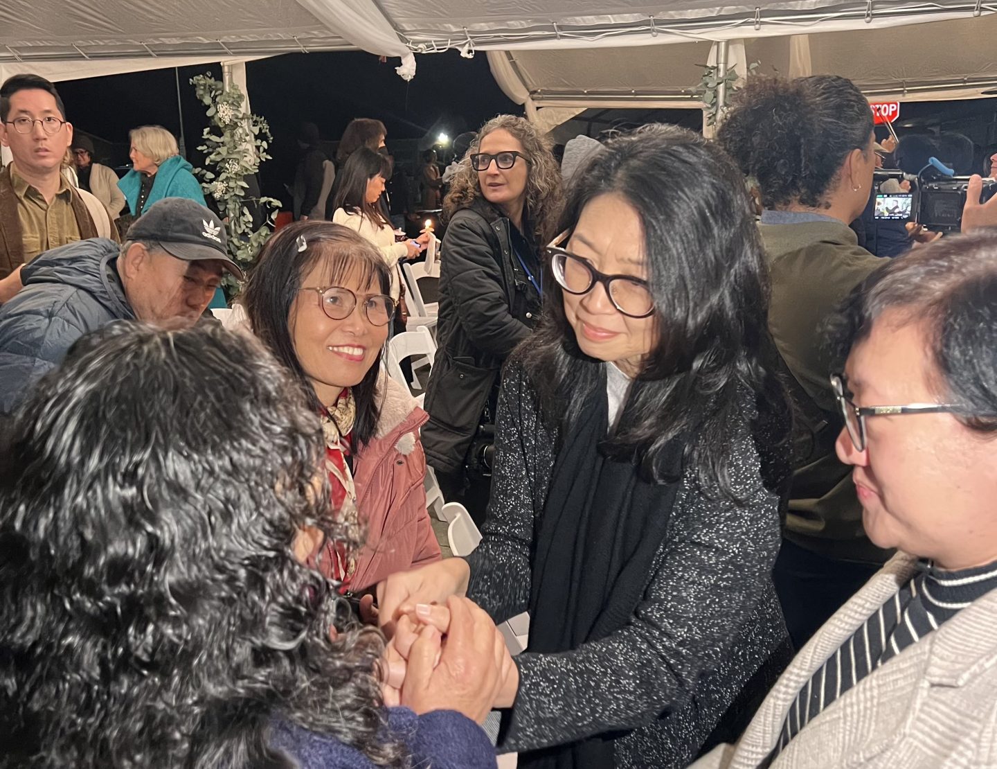Picture of Cynthia Choi shaking hands with a family member of a farmworker.